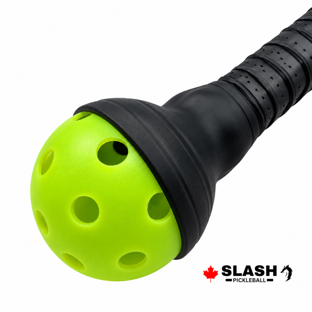 Black silicone ball retriever on the end of a paddle handle, holding a green pickleball